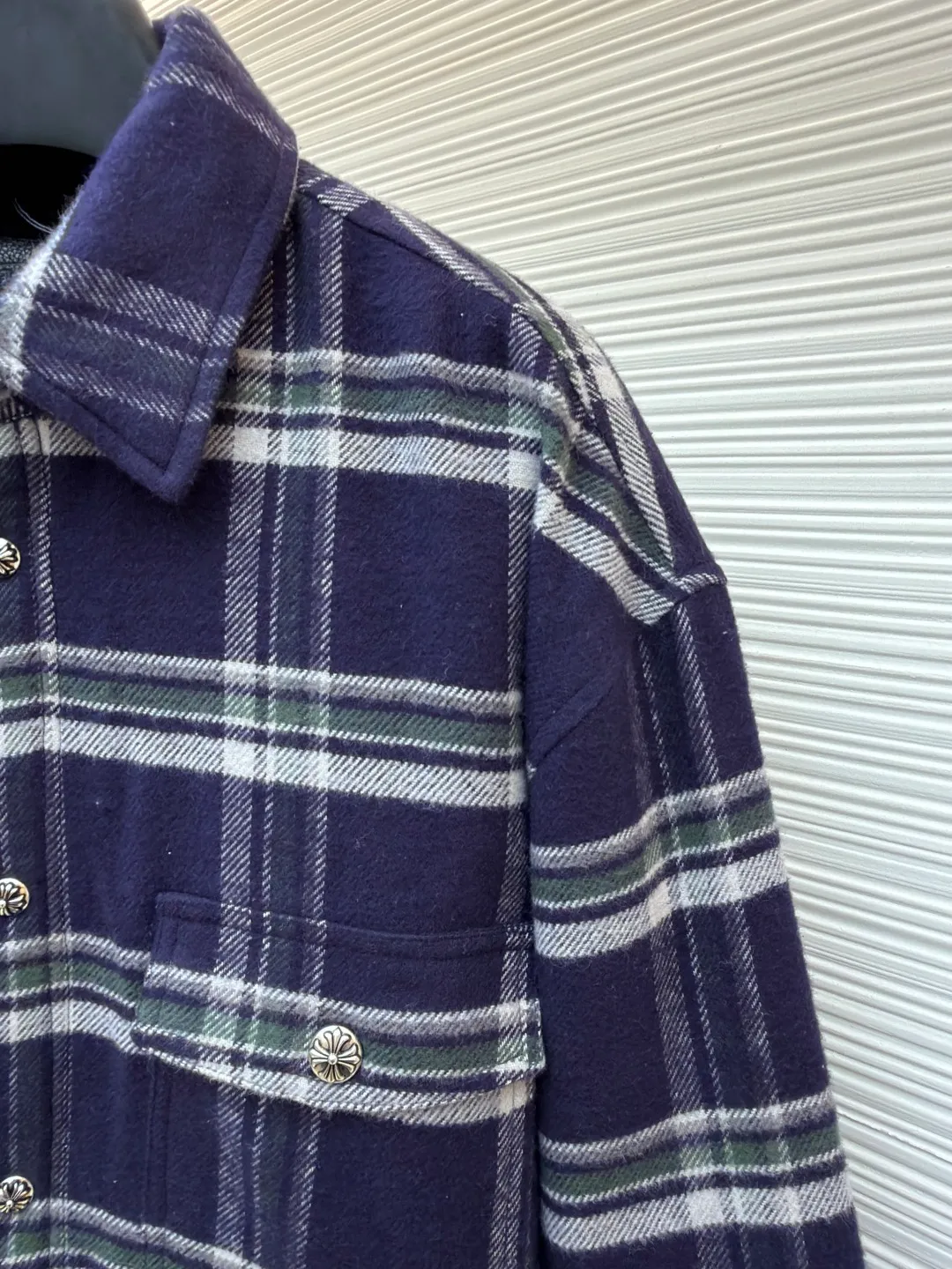 Chrome Hearts Contrast Checkered Lapel Shirt Jacket ●Item No.: 1682307-C05 ●Fabric: Cotton Fabric ●Technology: Made on Positioning Cutting Machine ●Color: Blue and White Plaid ●Version: Fitted ●Weight: Approximately 1030g ●Size: S-M-L-XL ●Description: This Louis Vuitton plaid shirt-style jacket is made of high-count wool blended brushed fabric imported from Italy. It is woven into a classic blue, white and green plaid pattern through yarn-dyed jacquard technology. The yarn is first dyed and then woven to ensure that the plaid color is clear and not easy to fade. The fabric has been pre-shrunk, and the shrinkage rate is controlled within 1%. The body pieces are cut using laser positioning, and the check pattern alignment error does not exceed 0.3cm. The double patch pockets on the front are sewn with welted three-dimensional sewing technology, and the edges of the pockets are padded for a crisper shape. The placket is equipped with custom metal engraved snap buttons, which accurately echo the plaid pattern of the body; the shoulders are made of seamless epaulette splicing technology, and the wiring is smooth and seamless. The double-needle locking technology on the cuffs and hem enhances durability. The overall stitch length is maintained at 7 needles per centimeter, and the wiring is even and smooth. The lining is made of breathable cotton and linen blended materials, taking into account texture and wearing comfort, fully demonstrating the brand's exquisite clothing technology. The overall wiring is straight and delicate, the fabric is comfortable and soft, and the color is consistent without color difference. It can be matched with the same style to create a fashionable look and control various occasions. Customized accessories, complete with three standards, same style for men and women!